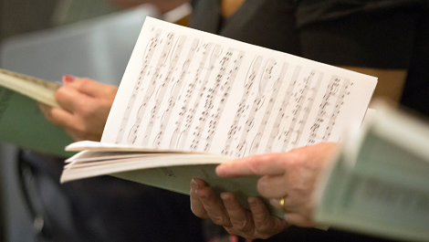 choristes tenant en main des partitions musicales